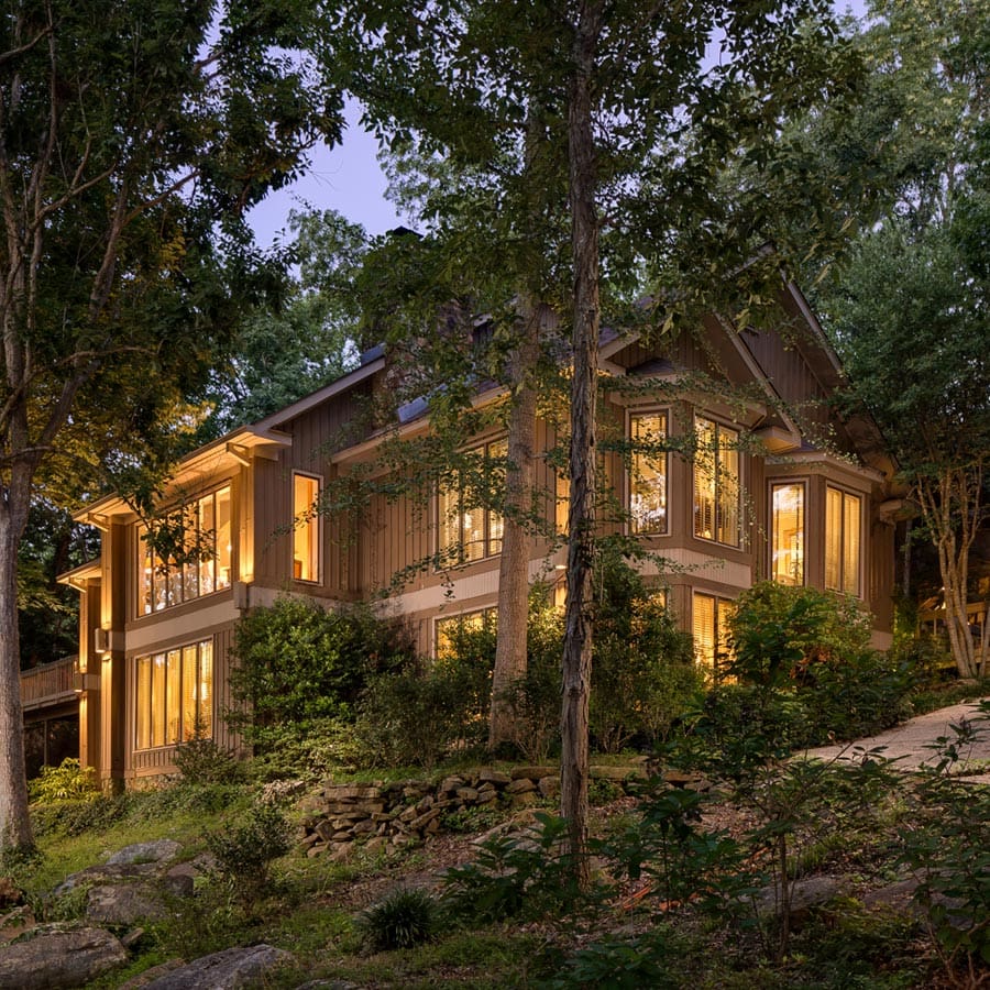 Wood home in Huntsville, Alabama at night with trees and rocks surrounding. Exterior Architecture