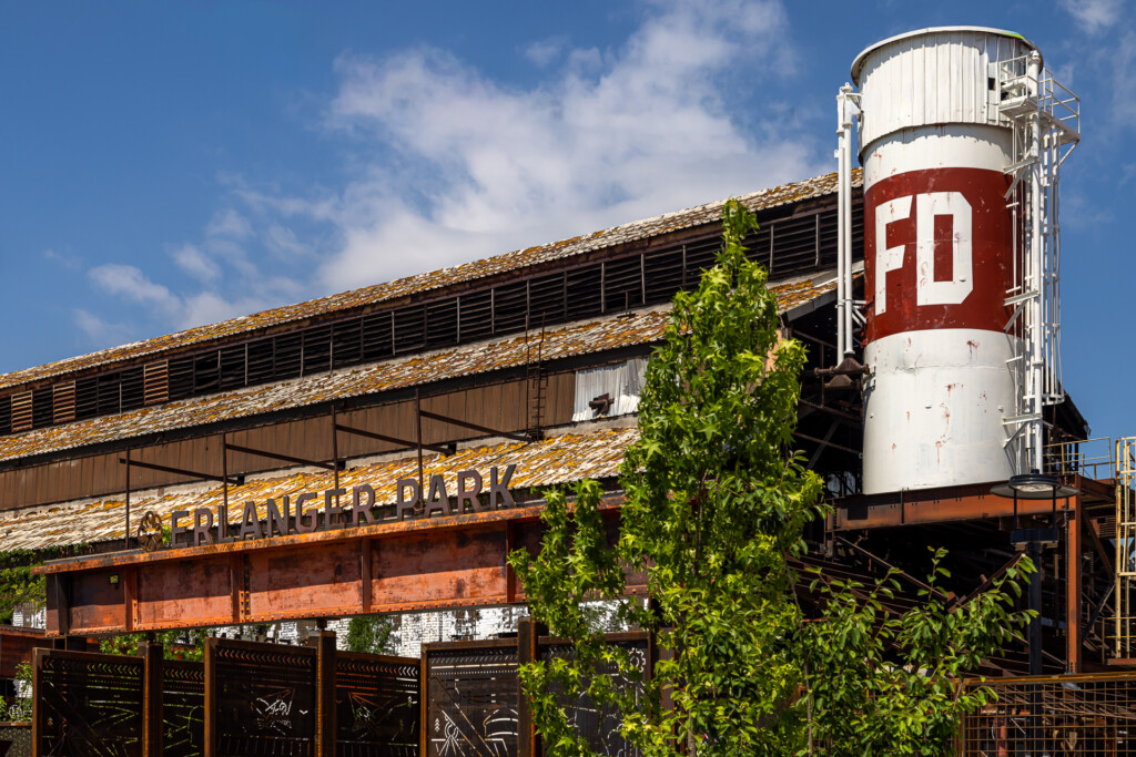 Erlanger Park - Chattanooga Lookouts - Weathered industrial warehouse with wooden siding and metal water tower marked FD, ivy climbing the structure against blue sky