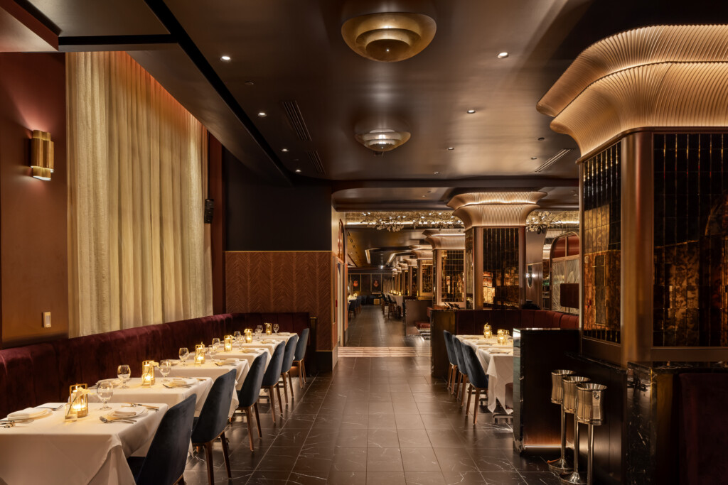 Philippe Chow - Nashville - Elegant restaurant interior with burgundy banquettes, white table linens, brass fixtures, dark ceiling, and contemporary pendant lights